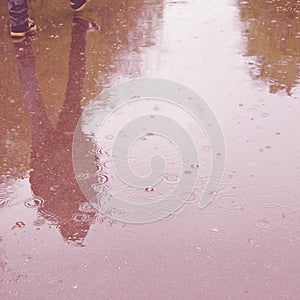 Walking people, reflection in the wet asphalt - vintage effect.