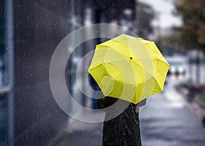 Walking on rainy day with yellow umbrella