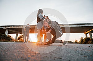 Walking on the road. Group of young cheerful friends having fun together. Party outdoors