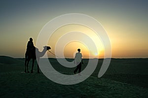 A walking in the Sahara desert, in the sunset light