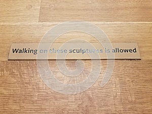 walking on sculptures allowed sign on wood floor