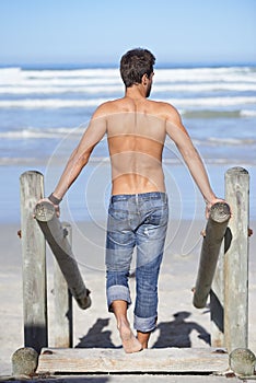 Walking, shirtless and back of man at the beach on tropical vacation, adventure or holiday. Travel, stairs and confident