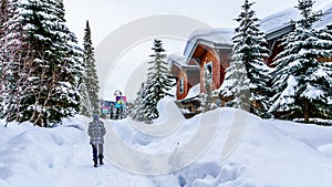 Walking through the snow along the colorful houses in the Village of Sun Peaks