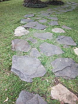 Walking stone path in a grass side park