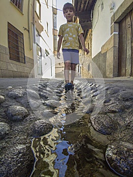Walking by street water channel at Losar de la Vera, Spain
