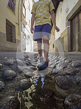 Walking by street water channel at Losar de la Vera, Spain