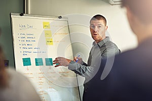 Walking the team through the work process. a man giving a presentation to colleagues in an office.