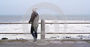 Walking, thinking and woman on promenade by ocean with sadness for memories, nostalgia and reflection. Depression