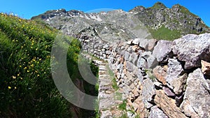 Walking in the trenches of the First World War. POV of the hiker. Impressive view of the ruins. Cadorna front line. Orobie Alps