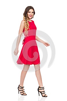 Walking Woman In Red Dress And High Heels Is Smiling