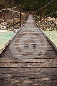 Walking on wooden footbridge crossing over turquoise river of soca, triglav national park, slovenia