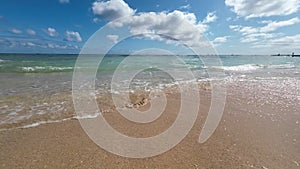 Walking on the yellow sands of the famous Waikiki beach. Warm waves of the Pacific Ocean wash over a tropical Waikiki