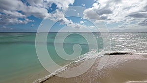 Walking on the yellow sands of the famous Waikiki beach. Warm waves of the Pacific Ocean wash over a tropical Waikiki