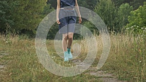 Walking young teen girl in dress and boots, on country road, nature background, rustic style