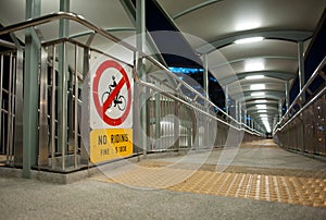 Walkway across a bridge with a no riding sign