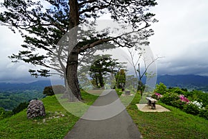 Walkway and benches in Japanese garden on mountaintop with panorama view