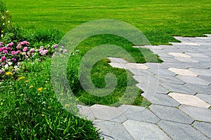 walkway with concrete tiles honeycomb pattern and flowerbed.