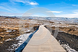 Walkway of gullfoss waterfall in Iceland surrounding by grass field with blue sky