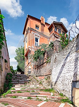 Walkway with red bricks stairs leading to old traditional building and trees, Balat district, Istanbul, Turkey