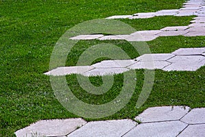 walkway with stone tiles honeycomb pattern on summer park.