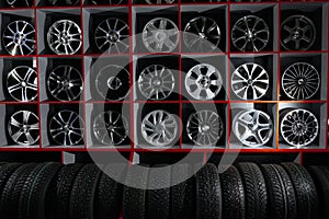 Wall of alloy car wheels and pneumatic tires in store. seasonal wheel storage