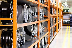 Wall of alloy car wheels and pneumatic tires in store. seasonal wheel storage