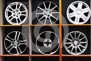 Wall of alloy car wheels and pneumatic tires in store. seasonal wheel storage