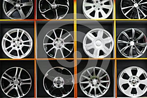 Wall of alloy car wheels and pneumatic tires in store. seasonal wheel storage