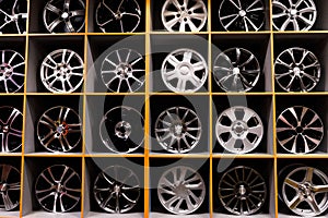 Wall of alloy car wheels and pneumatic tires in store. seasonal wheel storage