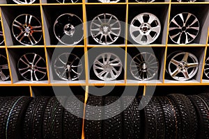 Wall of alloy car wheels and pneumatic tires in store. seasonal wheel storage