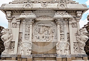 Wall of ancient Indian Kailasa temple VII century with sculptures of gods Shiva, Parvati and their retinue. South India.