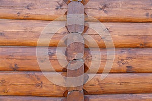 Wall background of round logs house, covered with protective impregnation.