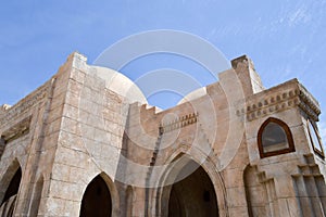 A wall with a beautiful texture of a Muslim Islamic Arab mosque made of white brick architecture with arches, tall towers, domes a