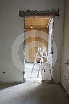 Wall breakthrough for a room door, behind it a painter\'s ladder