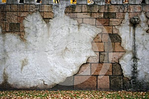 Wall with bricks and fragments of cement, cracks and drips