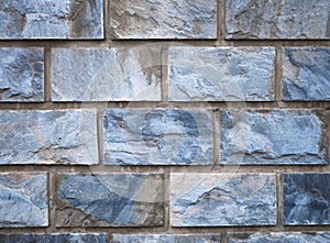 Wall of brown and blue ashlar and mortar stones