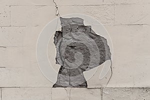 The wall of the building with a deep crack and fallen plaster