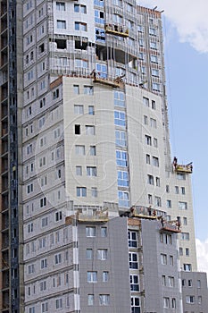 On the wall of the building are hung winches for exterior decoration. The buildings under construction are visible.