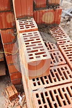 Wall building with professional bricks, construction site of new house.