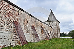 Wall with buttresses and tower of ancient monastery