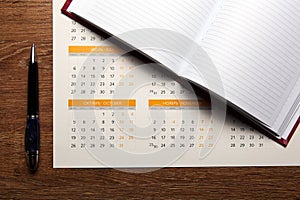 Wall calendar with pen and diary closeup