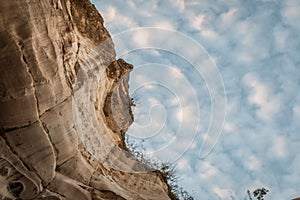 Wall of a cave and clouds with blue sky