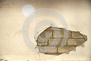 The wall caved in, the plaster and the bricks are visible.