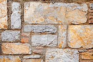 Wall from chipped stone, texture of brown and yellow stone background texture