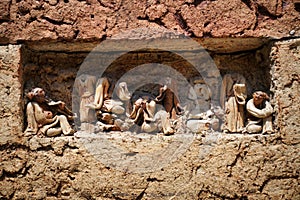 A wall of clay bricks with small figures of people