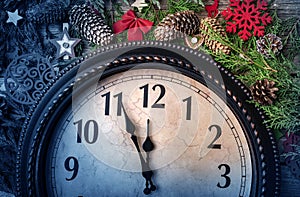 Wall clock in Christmas or New Year decorations are wrapped with fir branches and Christmas decorations. On the clock