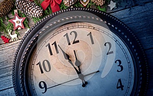 Wall clock in Christmas or New Year decorations are wrapped with fir branches and Christmas decorations. On the clock