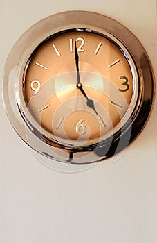 Wall clock indicating 5 (five)