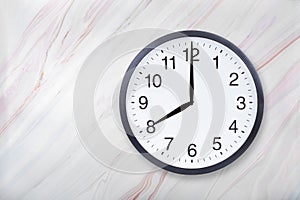 Wall clock show eight o`clock on marble texture. Office clock show 8pm or 8am