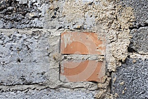 two red bricks in grey wall